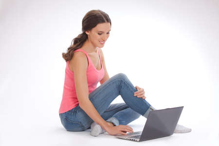 Beautiful young woman with laptop  on white backgraundの写真素材