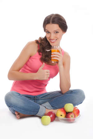 pretty excited  happy smileyoung woman holding glass of orange juice in hand over white backgroundの写真素材