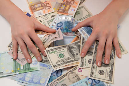 women\'s hands are covered banknotes of the Euro and the dollarの写真素材