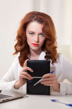 Beautiful young business woman with laptop in officeの写真素材