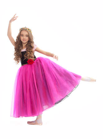 Beautiful young female classical ballet dancer on pointe shoes wearingblack leotard pink stockings and purple dress isolated on white studio background in the crownの写真素材