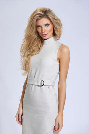 beautiful woman with long hair in beige dress on white backgroundの写真素材