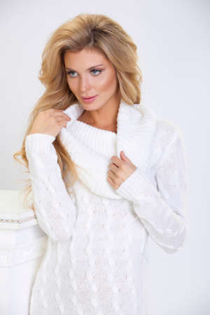 girl in a white knitted dress with long hair on a white backgroundの写真素材