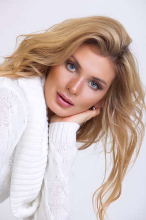 girl in a white knitted dress with long hair on a white backgroundの写真素材