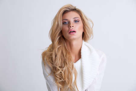 girl in a white knitted dress with long hair on a white backgroundの写真素材