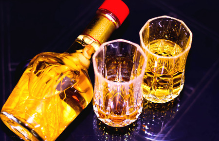 ginger root chinese wine bottle with glasses of whiskey on glass table ready to be served in a a prty. wine bottle , health drinkの写真素材