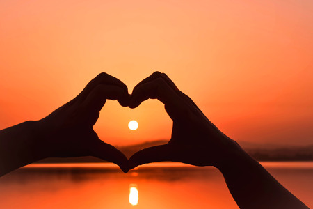 SUNRISE VIEW THROUGH THE HEART SHAPE HANDS CONCEPT OF LOVE FRIENDSHIP ,VALENTINE  & NEW HORIZON OF LOVE .の写真素材