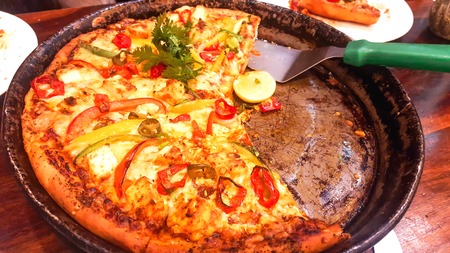 VEGETARIAN PIZZA SERVED ON BLACK PANの写真素材