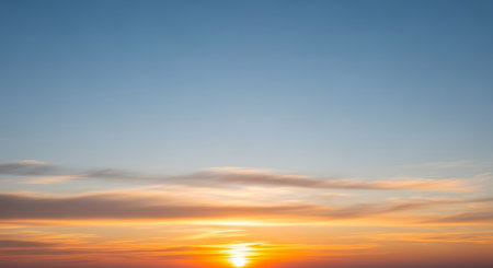 A vibrant sunset sky with orange and blue hues and soft clouds creates a peaceful and warm atmosphere perfect for travel, relaxation, or nature-themed content.の素材