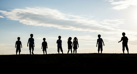 Silhouette of a group of children on the field at sunsetの素材