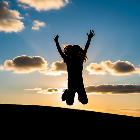 Silhouette of a little girl jumping on the sunset background.の素材