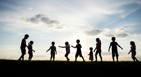 Silhouette Group of Kids Playing in the Field at Sunset Conceptの素材