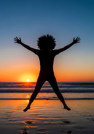 Silhouette of African American woman jumping on the beach at sunsetの素材