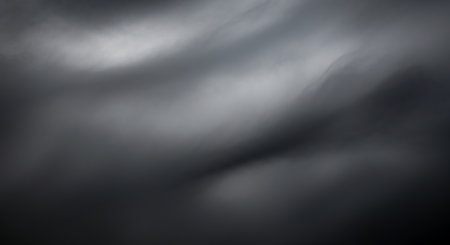 Dark stormy clouds swirling in a gray sky create a moody atmospheric scene perfect for weather, nature, and dramatic background marketing materials.の素材