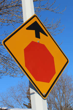 Stop Sign Ahead Against Blue Sky and Treesの写真素材