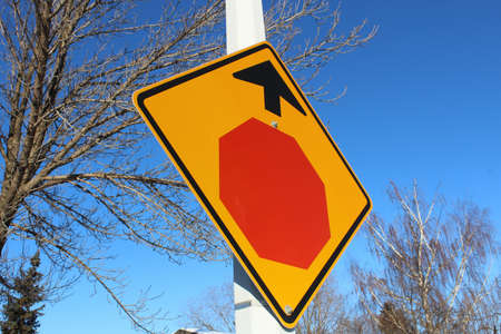 Stop Sign Ahead Against Blue Sky and Treesの写真素材