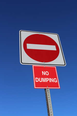 No Entry or Dumping Sign Against Blue Skyの写真素材