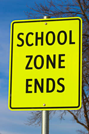 Close Up of School Zone Ends Sign Against Sky Background With Treeの写真素材