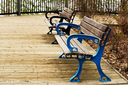 Two colorful benches on a boardwalk.
