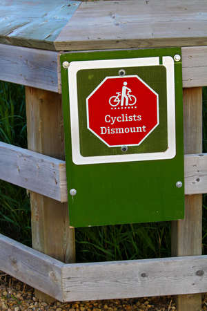 Closeup of a cyclists dismount sign on a fence.の写真素材