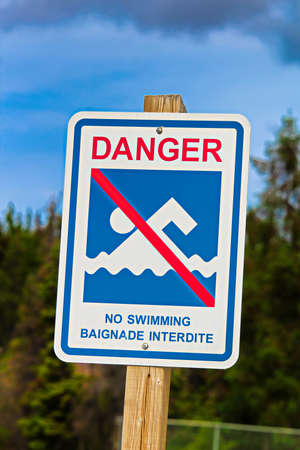 A danger, no swimming sign in both english and french.の写真素材