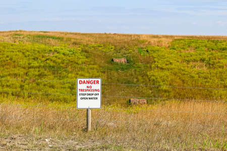 Danger no trespassing steep drop-off open water sign.の写真素材