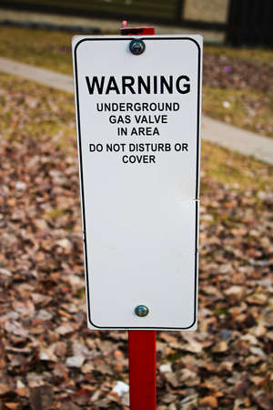 Warning underground gas valve do not disturb or cover sign.