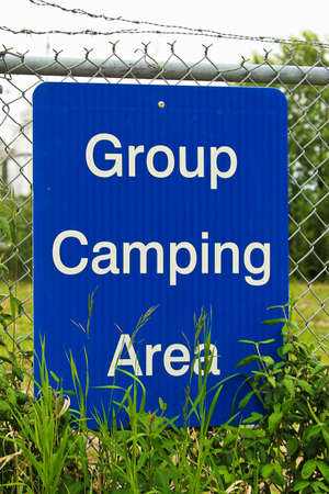 A blue group camping area sign on a fence.の写真素材
