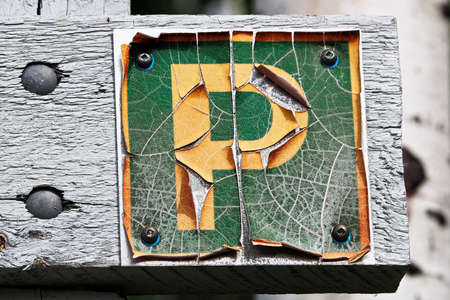 A faded peeling parking sign on wood.の写真素材