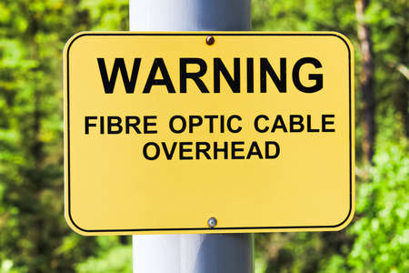 A warning fibre optic cable overhead sign.の写真素材