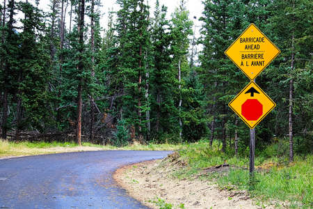 A Stop and Barricade Ahead sign along a roadの写真素材