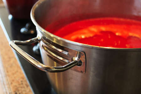A close-up of the handle of a pot of tomato sauce.の写真素材