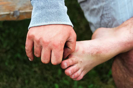 A hand holding onto a bare foot while sitting.