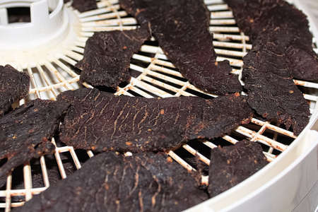 Closeup of jerky slices on a dehydrator rack.