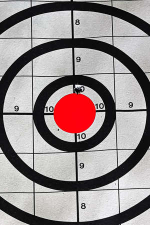 Closeup of a target bullseye with a bullet hole
