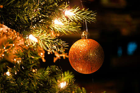 A sparkly Christmas ball ornament against a dark backgroundの写真素材