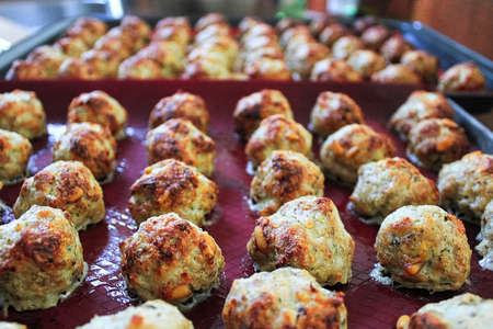 Baked meatballs on a red silicon matの写真素材