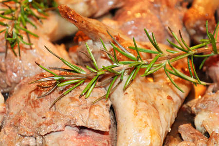 Closeup of rosemary over cut up duck piecesの写真素材
