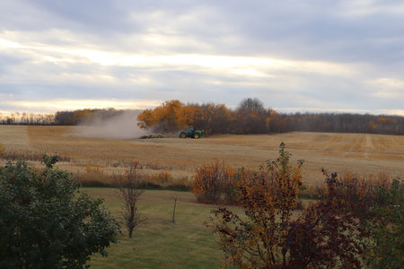 BONNYVILLE, ALBERTA, CANADA - SEPTEMBER 10, 2020: A local farmer in John Deere tractor works infront of a cloud of dust as he harrows a harvested fieldのeditorial素材
