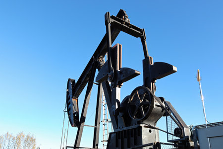 Silhouette of the oil pumpjack head against a blue skyの写真素材