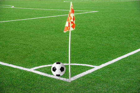 A flag at one corner of  football stadium with ballの写真素材