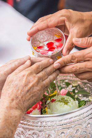 Pour water on the hands of revered elders and gives blessing in Songkran dayの写真素材
