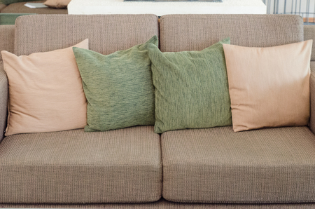 Four pillows on brown sofaの写真素材