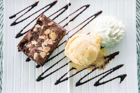 Vanilla ice cream Brownie and whipping cream in dish on tableの写真素材