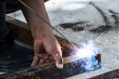 Worker welding steel with sparks lighting