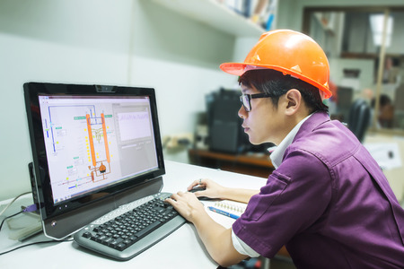 Engineer student looking simulated oil distillation in computerの写真素材