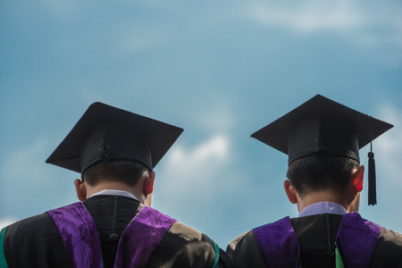 Backside of graduates with blue sky
