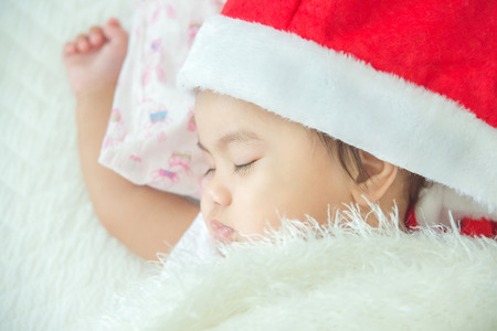 Newborn santa baby sleep in bedの写真素材