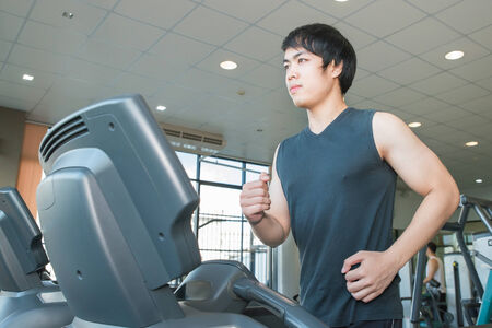 young people running on treadmill in gymの写真素材