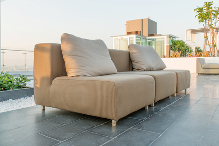 Chairs and a couch provide a place from a highrise rooftopの写真素材